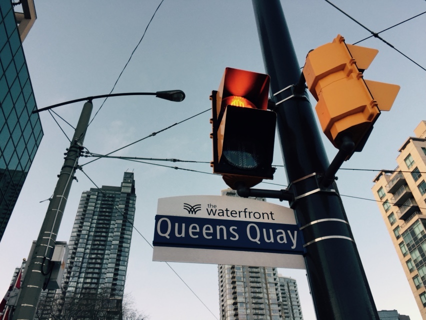 A street signs tells you you're on Queen's Quay in Toronto.