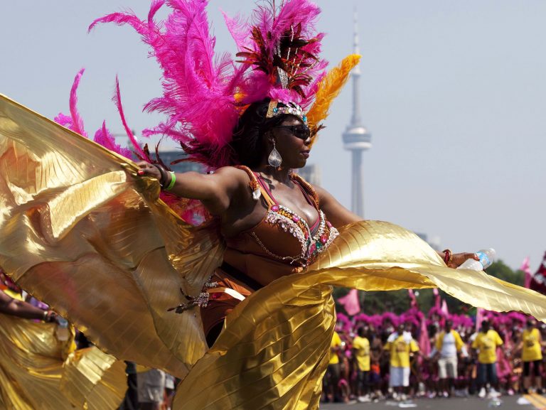 A masquerader performs on Lakeshore Boulevard during the Grand Parade at the Toronto Caribbean Carnival. THE CANADIAN PRESS/Michelle Siu
