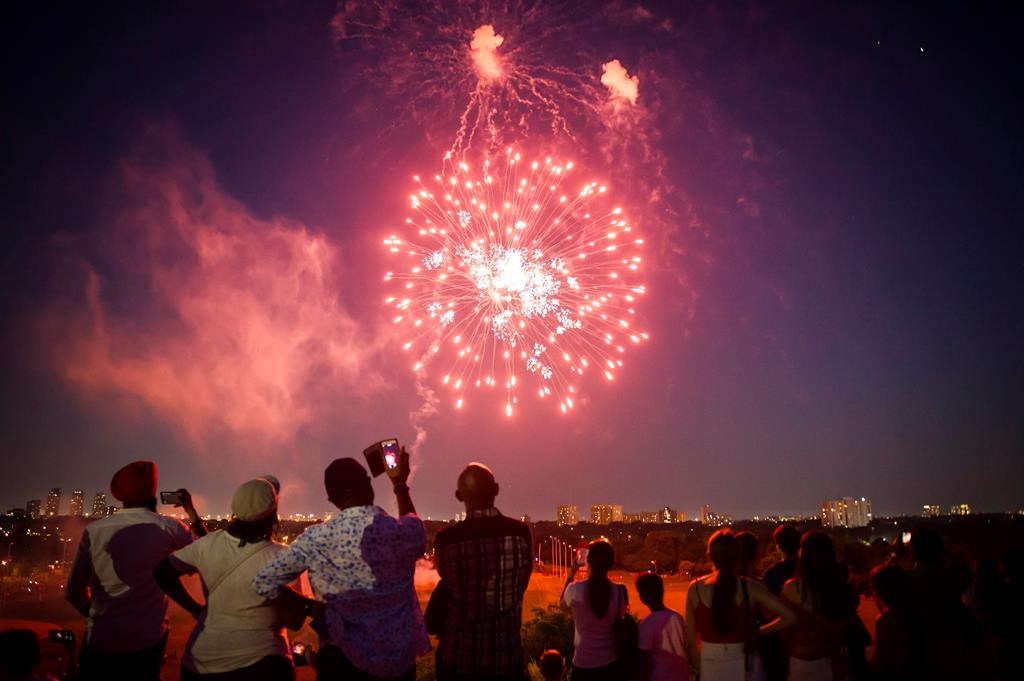 People watch a fireworks show in Centennial park as part of Canada Day celebrations, in Toronto on Sunday, July 1, 2018.