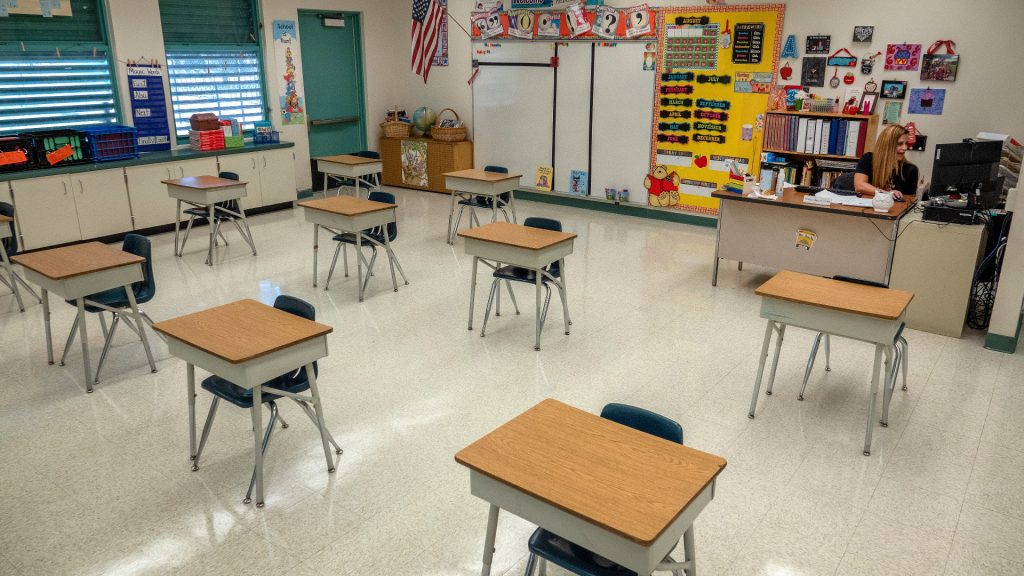Desks are arranged to maintain physical distancing between students in this elementary classroom.