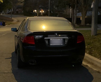 A black-coloured Acura TL sedan on darkened Richmond Hill street