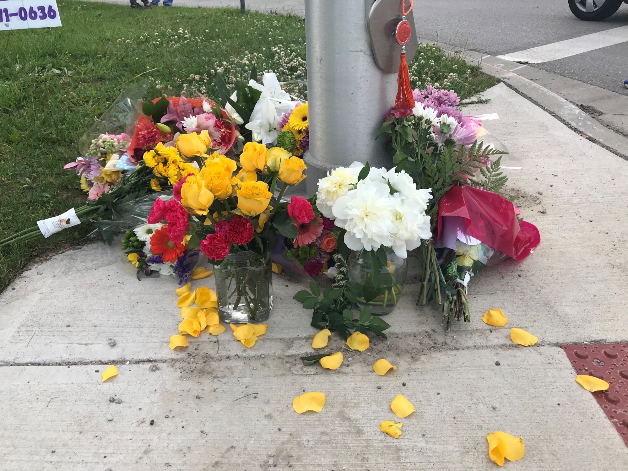 A small, makeshift memorial of flowers is pictured on June 7, 2021, on the London, Ontario sidewalk where a Muslim family of five was rundown by a vehicle in an attack police say was hate-motivated.