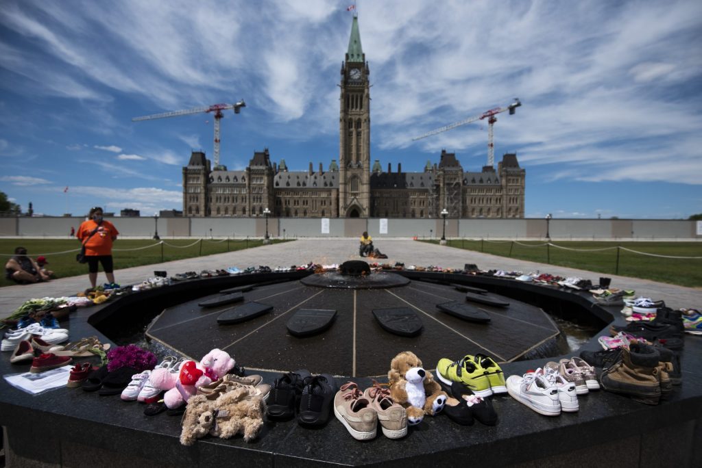 Shoes line the edge of the Centennial Flame on Parliament Hill in memory of the 215 children whose remains were found at the grounds of the former Kamloops Indian Residential School at Tk’emlups te Secwépemc First Nation in Kamloops, B.C., on May 30, 2021