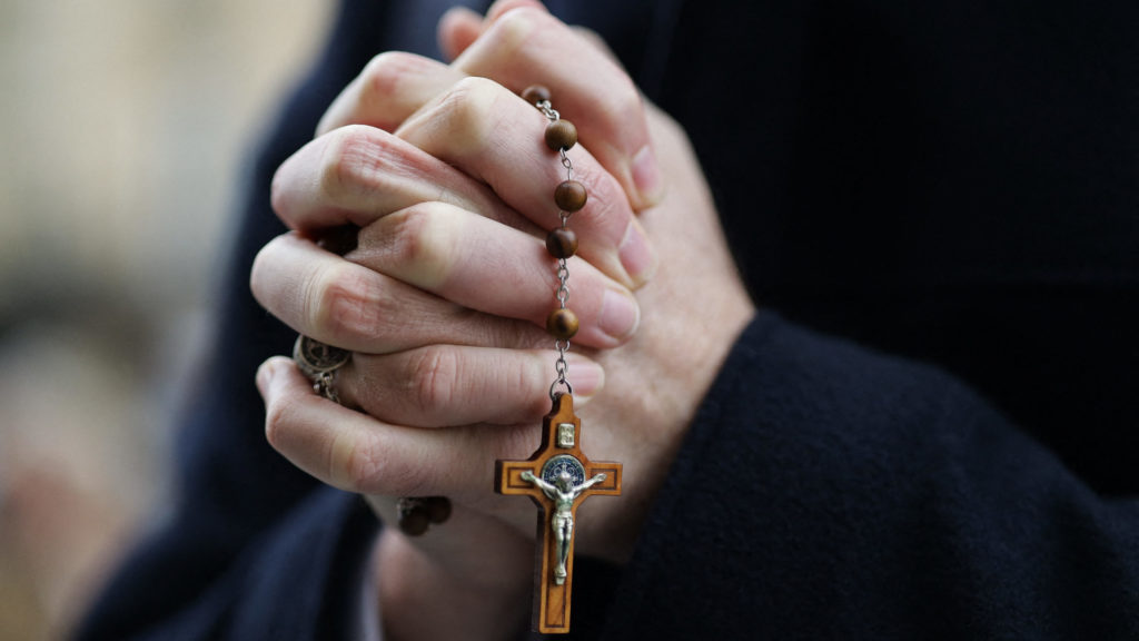 Hands praying with rosary