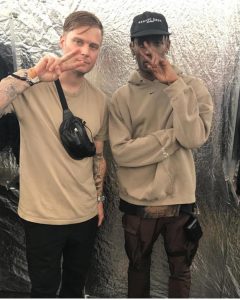 Musician Travis Scott pictured wearing a beige Nike hoodie