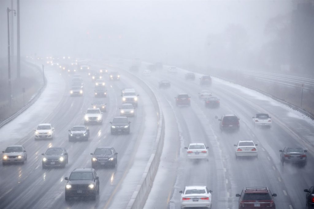 Cars drive along Lake Shore Boulevard as visibility diminishes through snow and rain in Toronto in 2018.