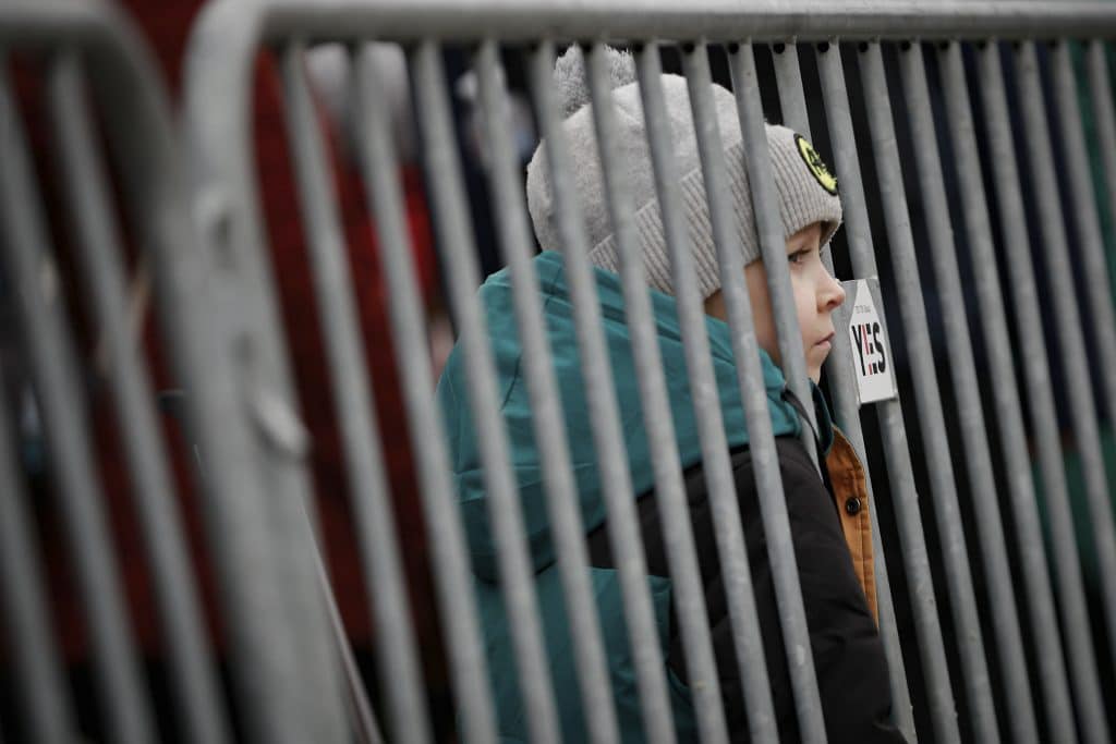 A young child looks through a barrier at the border crossing in Medyka, Poland