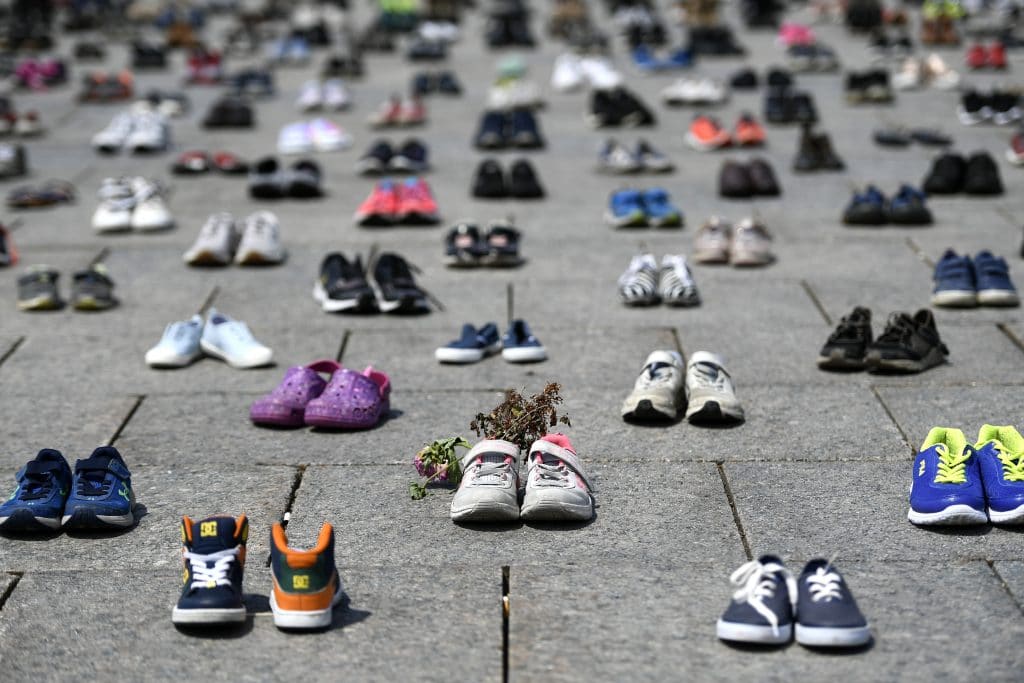 Dried flowers rest inside a pair of child's running shoes at a memorial for the 215 children whose remains were found at the grounds of the former Kamloops Indian Residential School