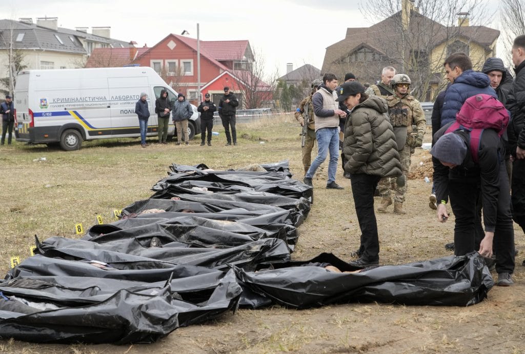 Ukrainian Prosecutor General Iryna Venediktova looks at the exhumed bodies of civilians 