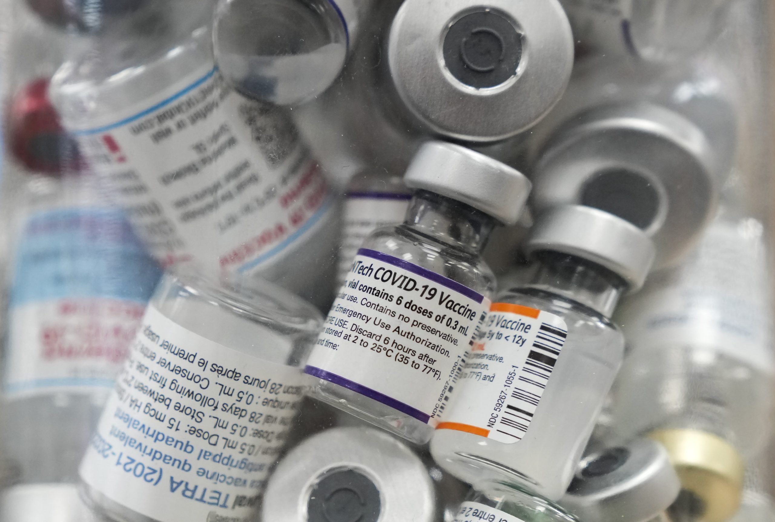 A jar full of empty COVID-19 vaccine vials