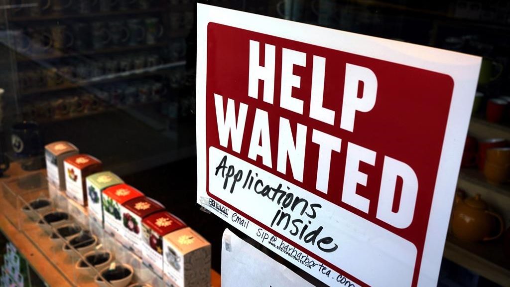 A help-wanted sign hangs in the front window