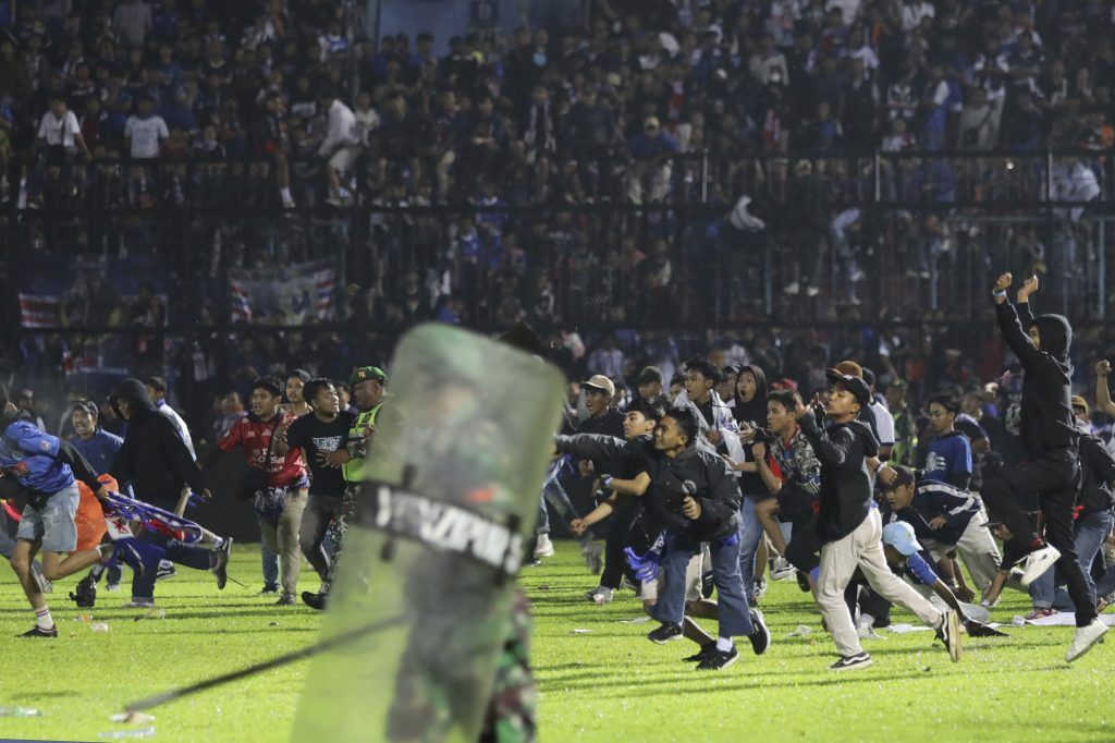 Soccer fans enter the pitch