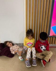 Sonia Hasnian and Syed Ali's children sit on the floor after being forced off a Sunwing flight.