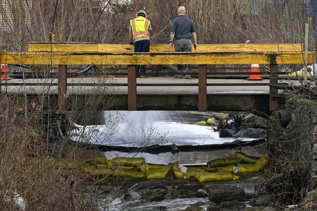 FILE - HEPACO workers, an environmental and emergency services company, observe a stream in East Palestine, Ohio, on Feb. 9, 2023, as the cleanup continues after the derailment of a Norfolk Southern freight train.