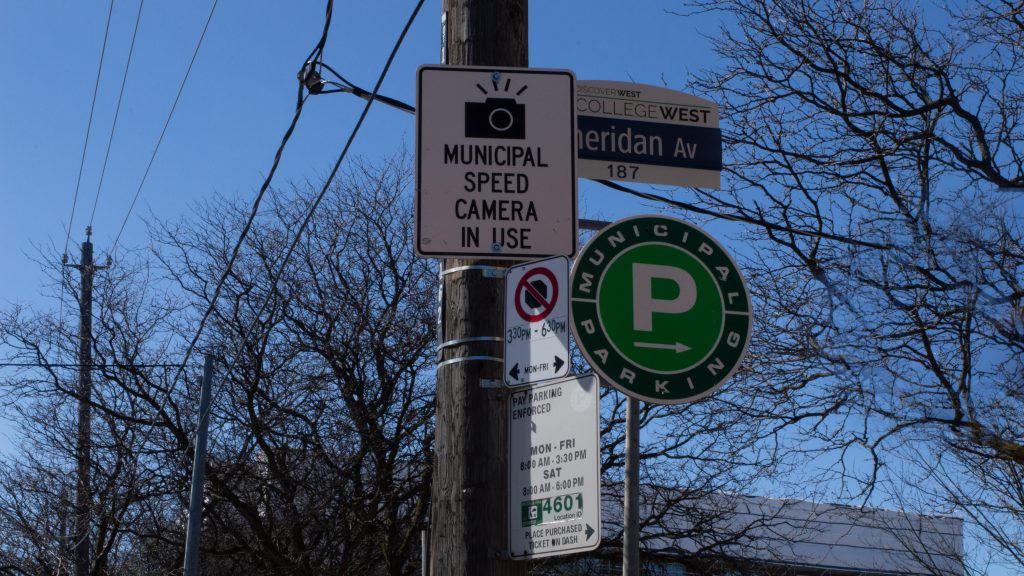 Municipal speed camera in use sign with Green P parking sign