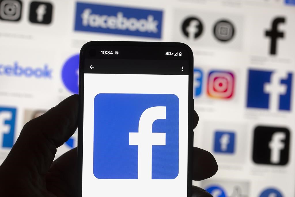 The Facebook logo is seen on a mobile phone