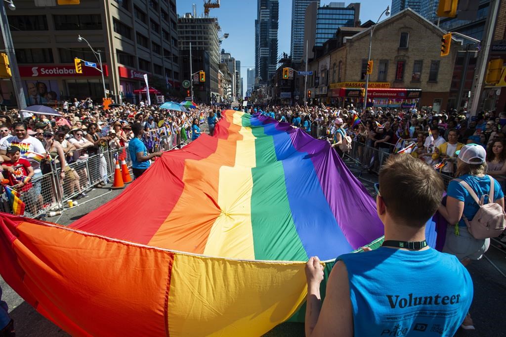 Volunteers with Pride Toronto carry a large rainbow flag during the 2019 Pride Parade in Toronto, Sunday, June 23, 2019. The city hosts its annual Pride parade today, with tens of thousands expected to join Canada's largest LGBTQ celebration. 