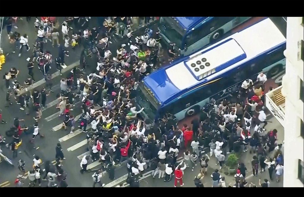  a crowd pushes up against a public transit bus