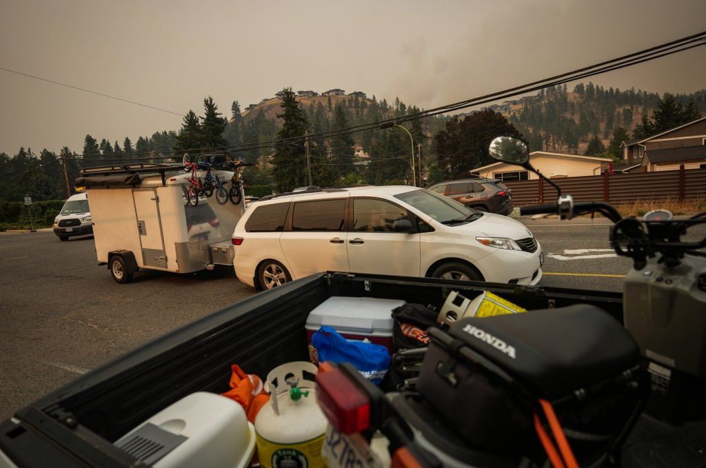 Evacuees leave with a trailer of belongings