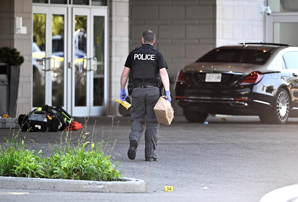 An Ottawa Police officer collects evidence after a shooting at the Infinity Convention Centre