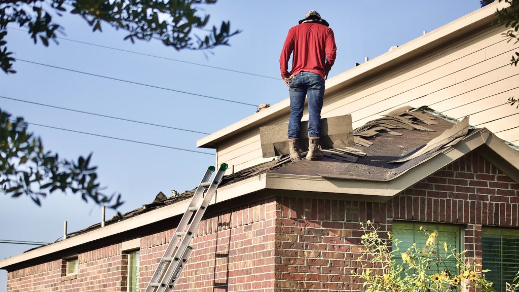 A man standing on the roof of a house