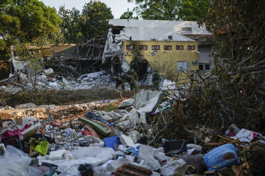 Israeli soldiers walk past houses destroyed by Hamas militants in Kibbutz Be'eri, Israel, Saturday, Oct. 14, 2023. Israel's consul general in Toronto says Canadian-Israeli peace activist Vivian Silver has been found dead. She was previously believed to be taken hostage in the Hamas attack on her community near the Gaza Strip on Oct. 7. THE CANADIAN PRESS/AP, Ariel Schalit