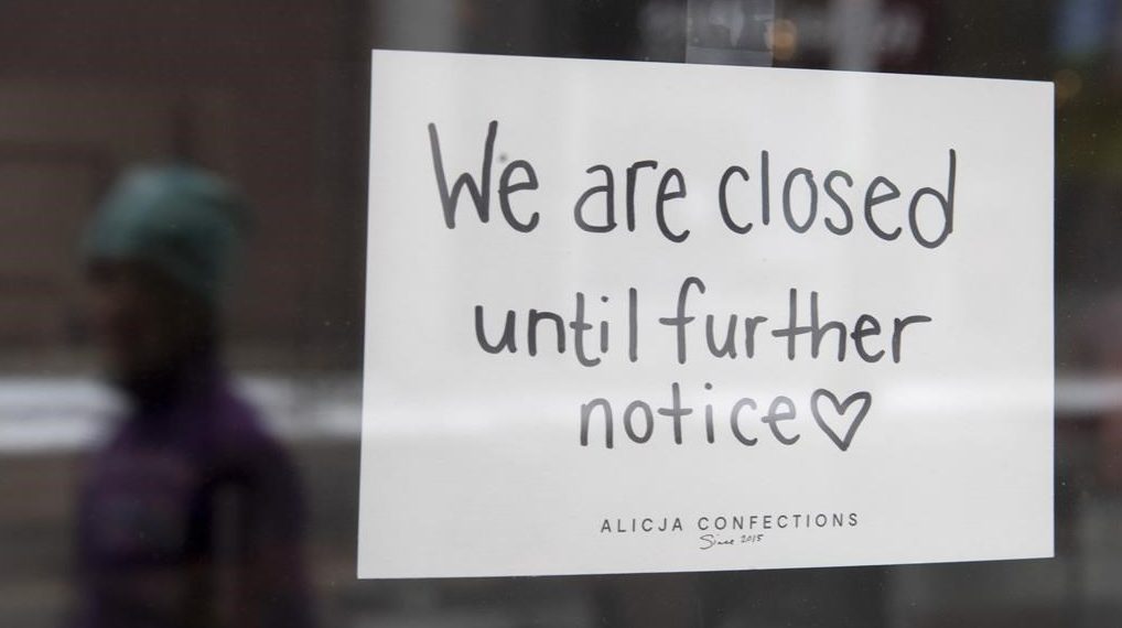 A sign on a shop window indicates the store is closed in Ottawa