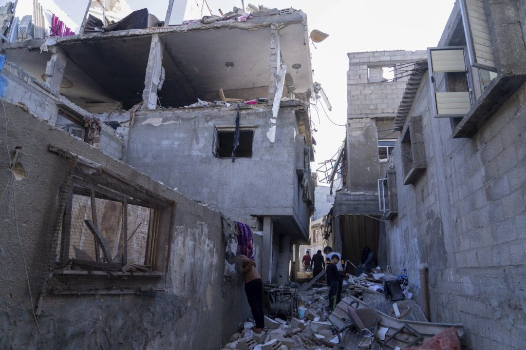 Palestinians inspect a damaged building following Israeli airstrikes