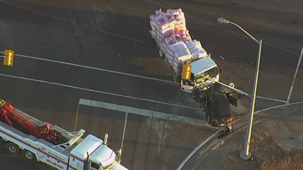 Aerial footage of a crash between a flatbed truck and a car at Highway 10 and Old School Road