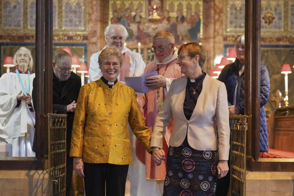 Reverend Catherine Bond, left and Reverend Jane Pearce react