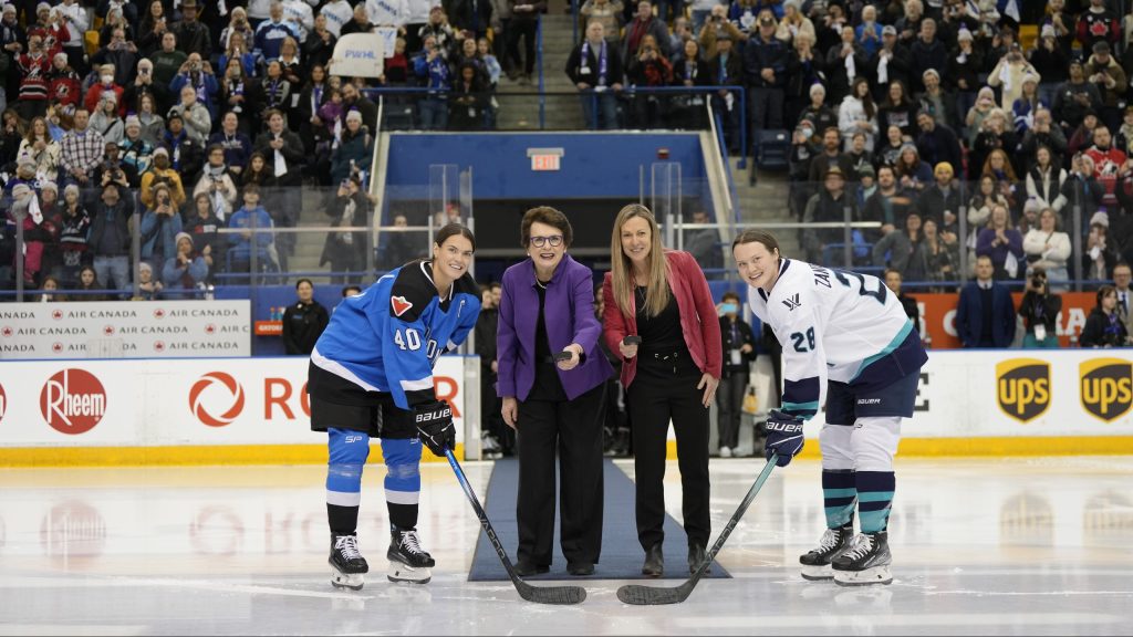 PWHL board member Billie Jean King (centre left) and PWHL executive Jayna Hefford prepare to drop pucks between Toronto captain Blayre Turnbull (left) and New York captain Micah Zandee-Hart (right) for the ceremonial faceoff before the inaugural PWHL game in Toronto on Jan.1, 2024.