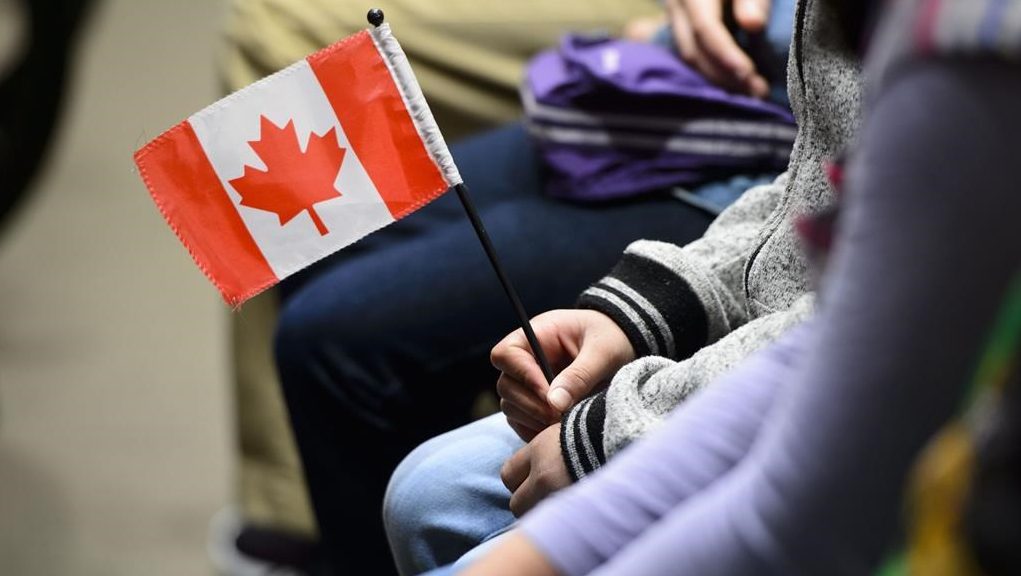 A Canadian holds a flag as she takes part in a citizenship ceremony on Parliament Hill in Ottawa on April 17, 2019