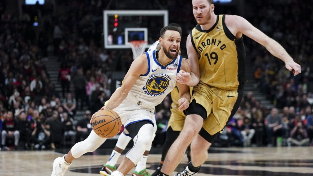 Golden State Warriors guard Stephen Curry drives past Toronto Raptors centre Jakob Poeltl