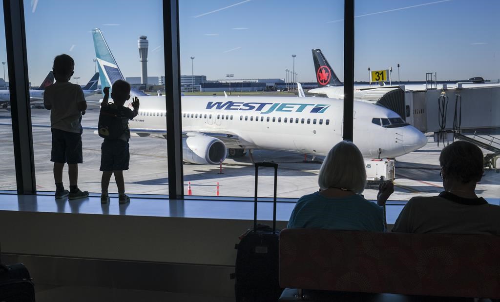 Young boys look out at Air Canada and WestJet planes