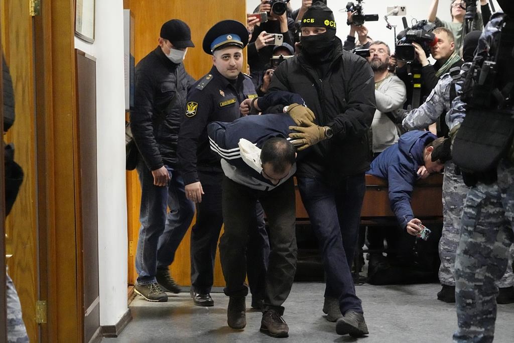 4 men charged in Moscow attack, showing signs of beatings at hearing as court says 2 accept guilt