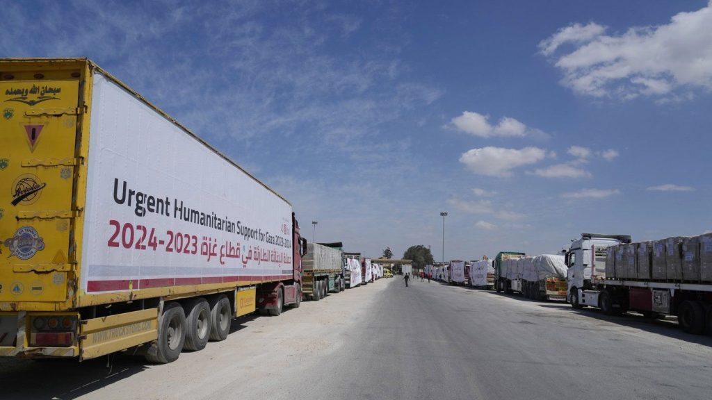 Egyptian humanitarian aids trucks line up to cross the Rafah border crossing between Egypt and the Gaza Strip