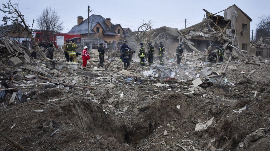 Ukrainian emergency workers clear the debris at the site of Russia's air attack