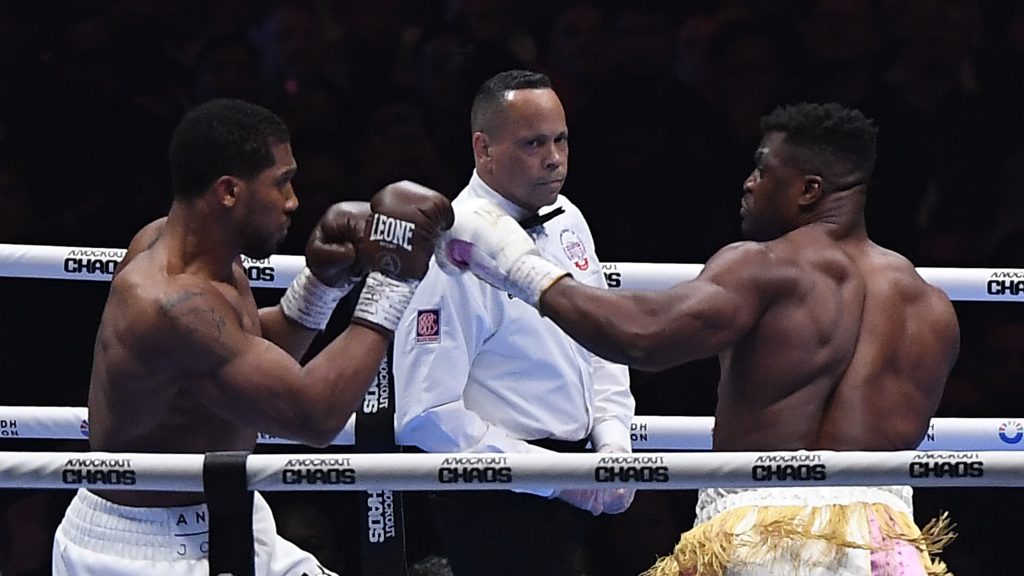 British former world champion Anthony Joshua, left, and MMA fighter Francis Ngannou fight during the heavyweight boxing showdown at Kingdom Arena