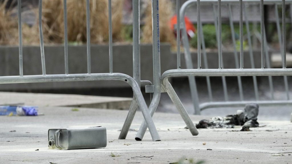 A metal can sits on the ground at the scene where a man lit himself on fire in a park outside Manhattan criminal court