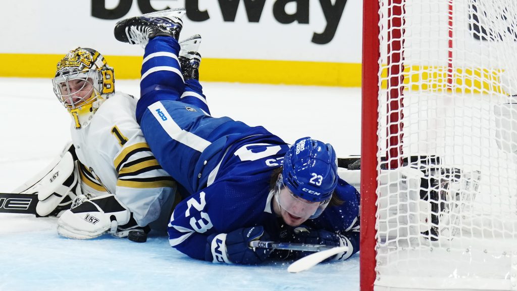 Toronto Maple Leafs' Matthew Knies (23) falls as he scores on Boston Bruins goaltender Jeremy Swayman