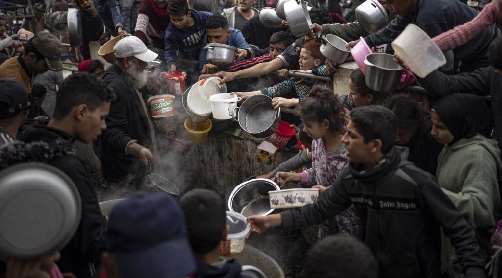 Palestinians line up for a meal in Rafah