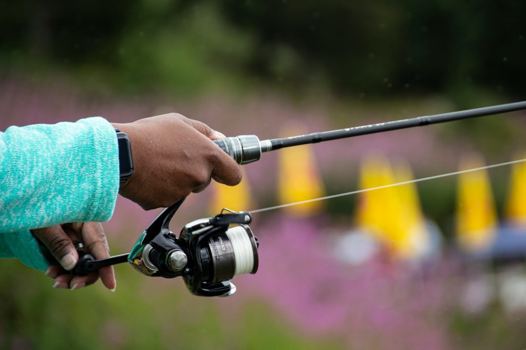 person holding black and silver fishing rod