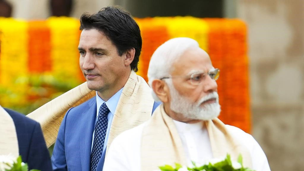 Prime Minister Justin Trudeau, left, walks past Indian Prime Minister Narendra Modi