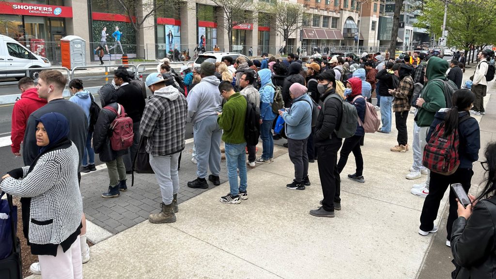 TTC riders wait for shuttle buses outside St. George Station on May 13, 2024