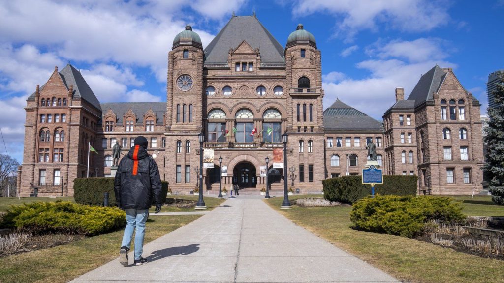 A man walks in front of Queen’s Park