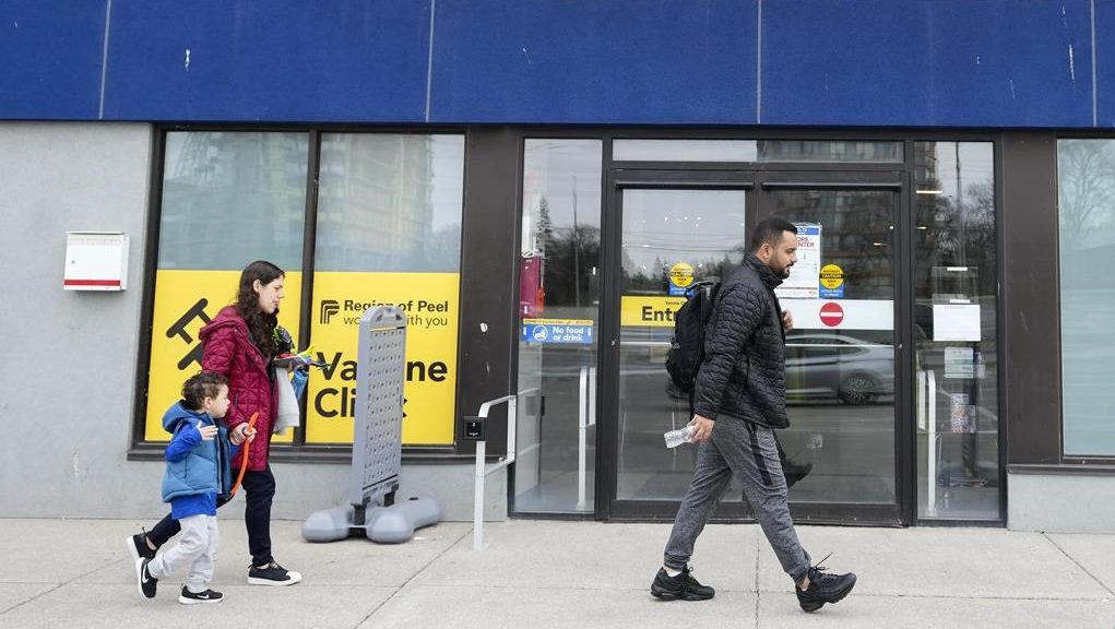People walk past a vaccine clinic during the COVID-19 Pandemic in Mississauga, Ont., on April 13, 2022