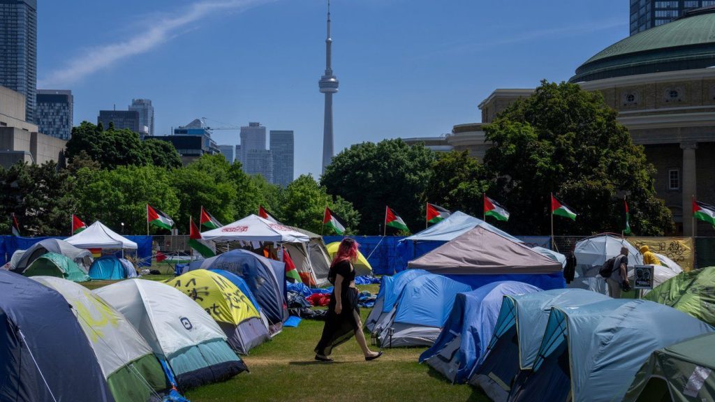 A woman walks between the tents in the pro-Palestinian encampment set up at the University of Toronto campus