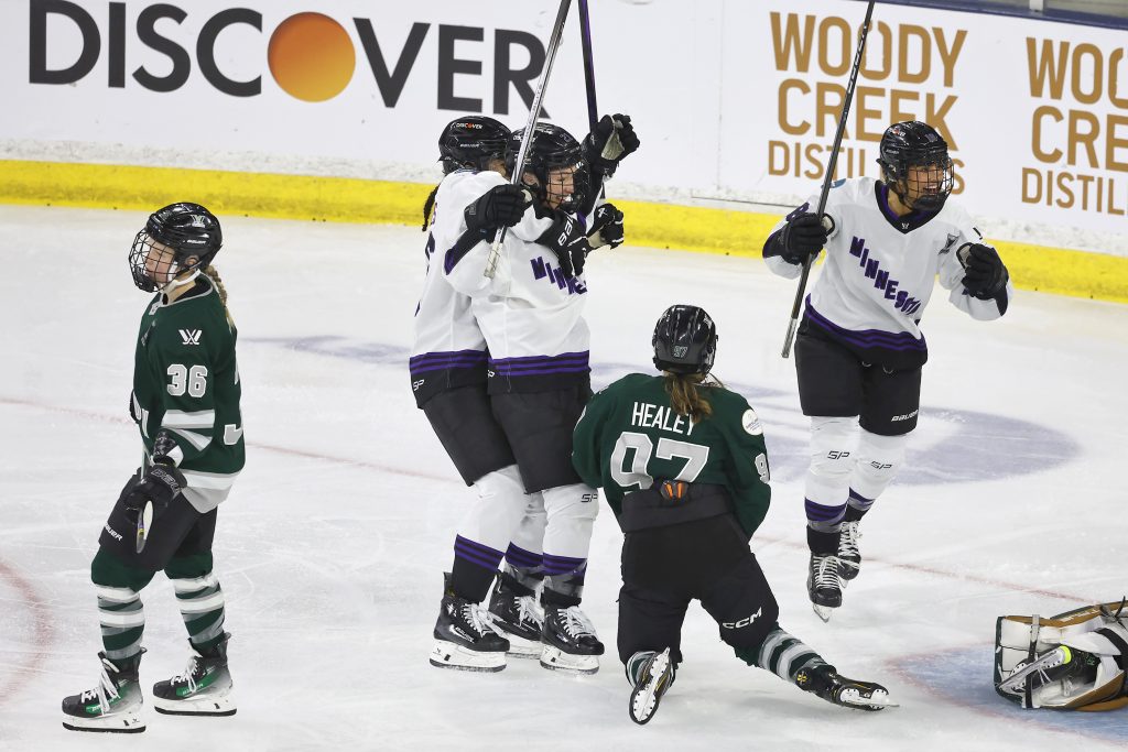 Minnesota forward Liz Schepers, center, is congratulated by teammate Sophie Jaques after Schepers scored a goal against Boston during the second period of Game 5 of the PWHL hockey finals Wednesday, May 29, 2024, in Lowell, Mass.