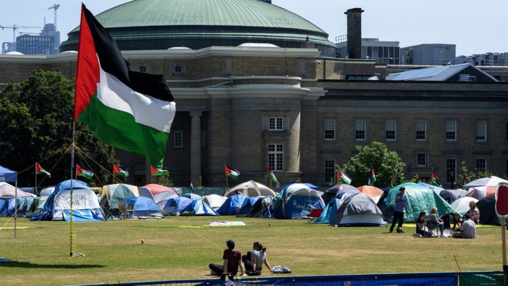 A Palestinian flag flies over the pro-Palestinian encampment set up in front of Convocation Hall at the University of Toronto campus