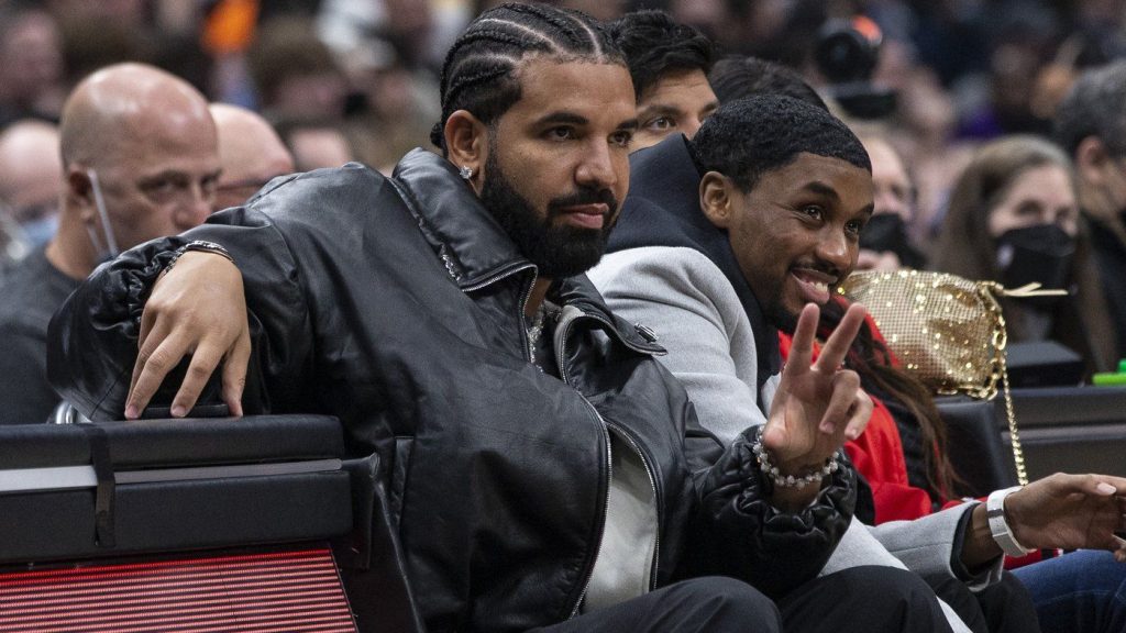 Drake gestures a he watches the Toronto Raptors